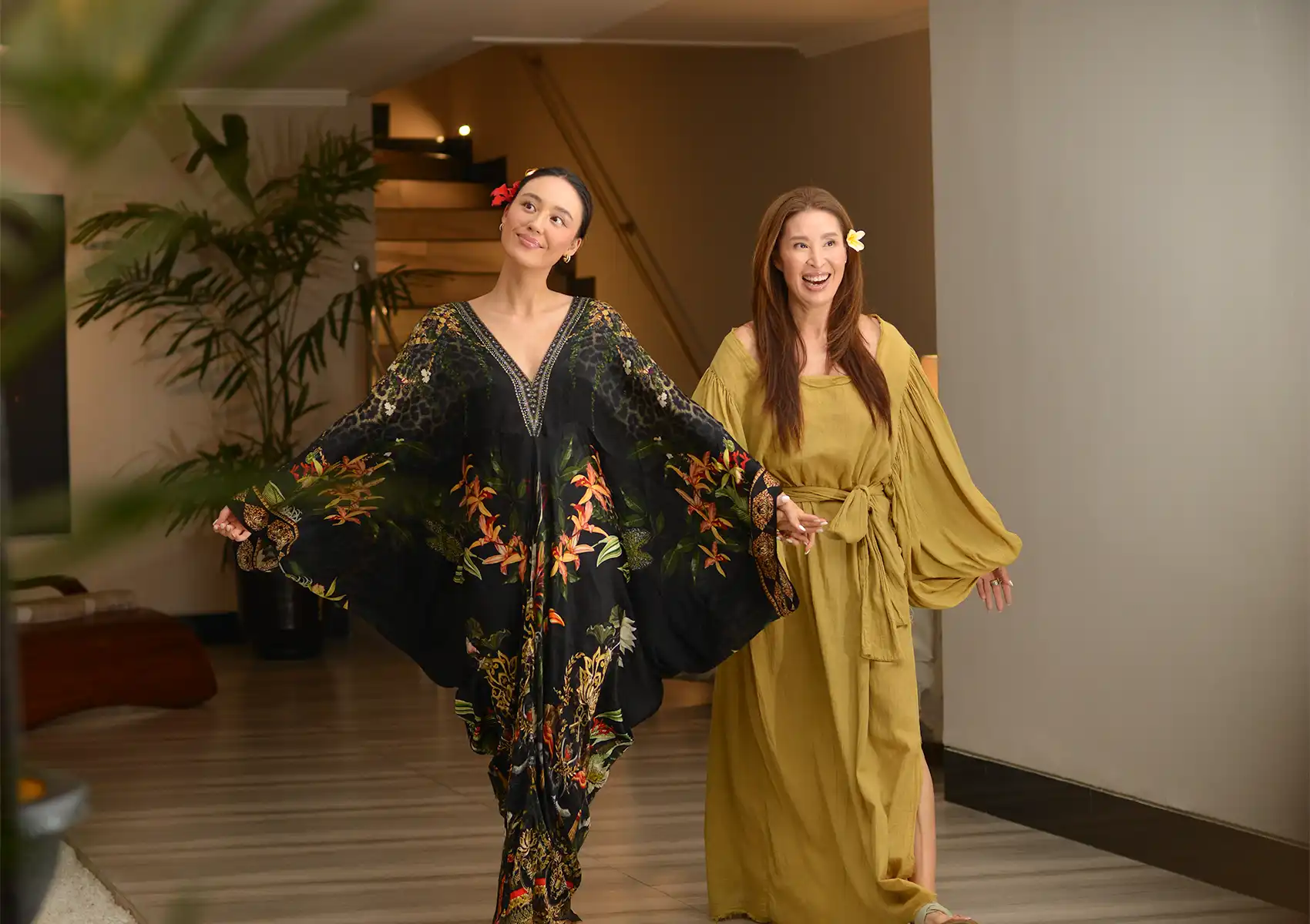 Two smiling women wearing elegant resort wear walking through the serene interior of a spa in ubud.