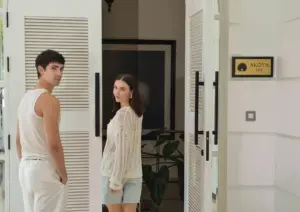 A casual couple smiling as they walk through the open white louvered doors of Akoya Spa, a welcoming day spa in Ubud.