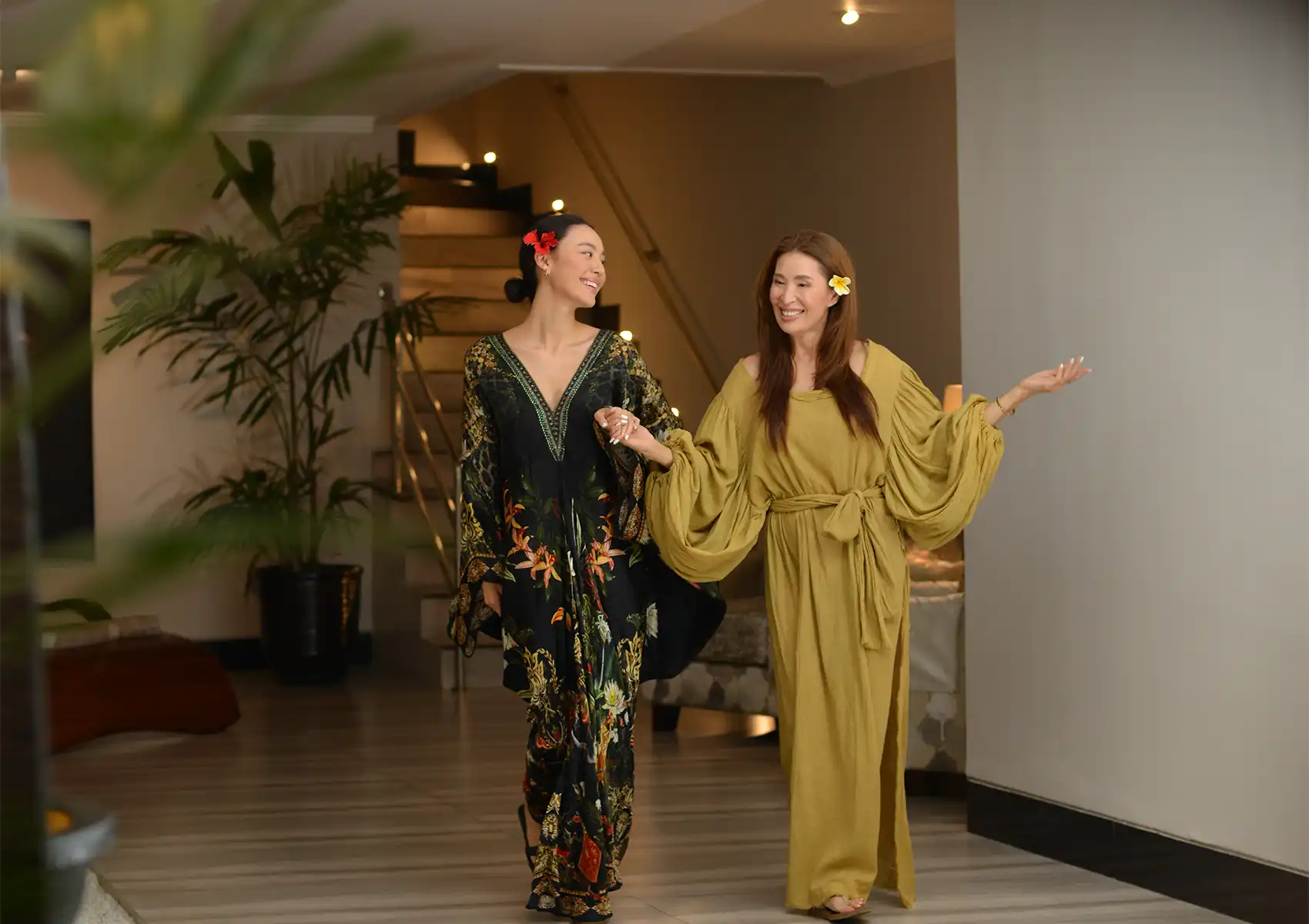 akoya-spa-exterior Two smiling women holding hands and walking through the elegant interior of the best spa in Ubud.