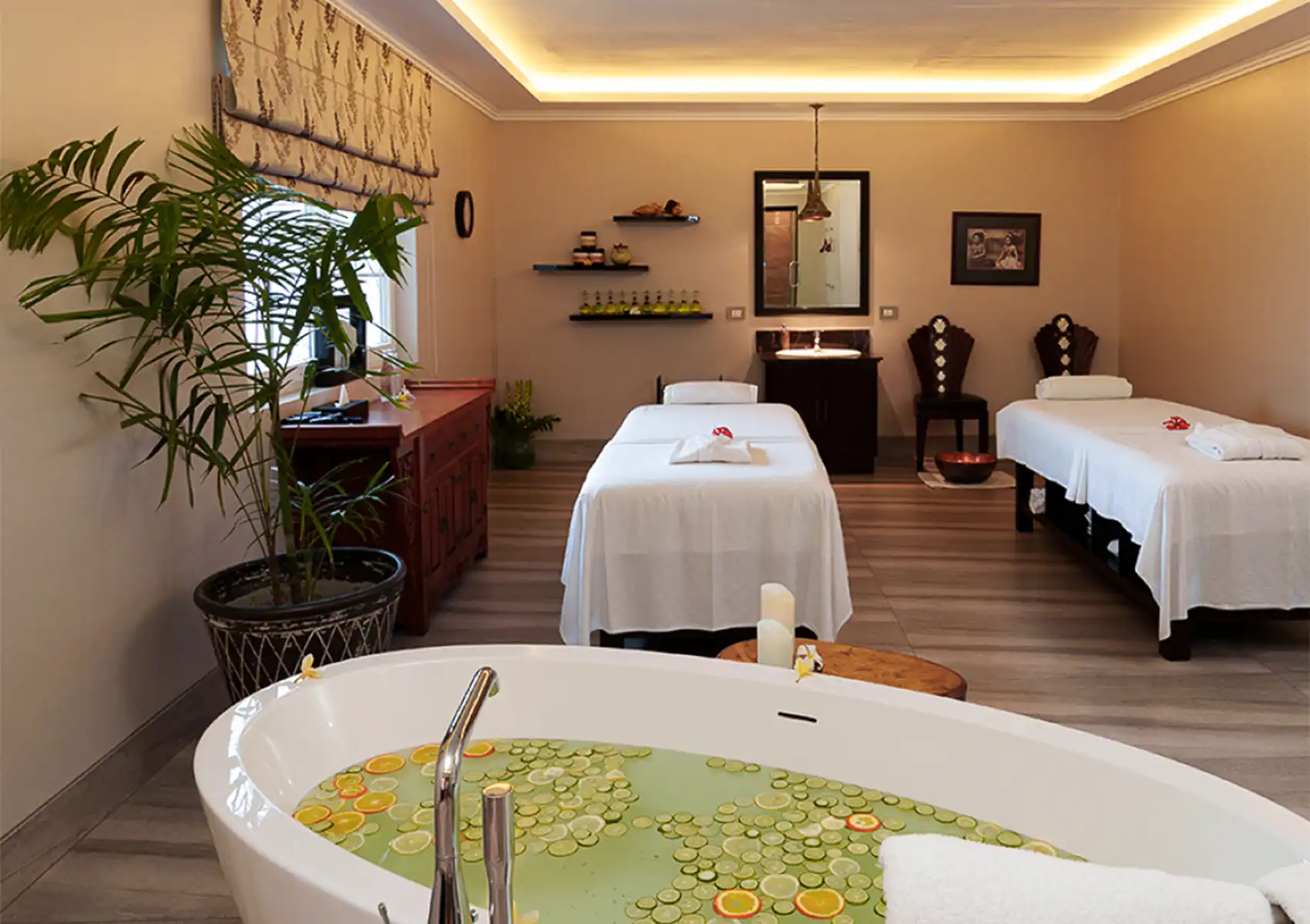facial-treatment-room-at-akoya-spa A tranquil couples treatment room featuring two massage beds and a large freestanding soaking tub filled with citrus slices at the best spa in ubud.