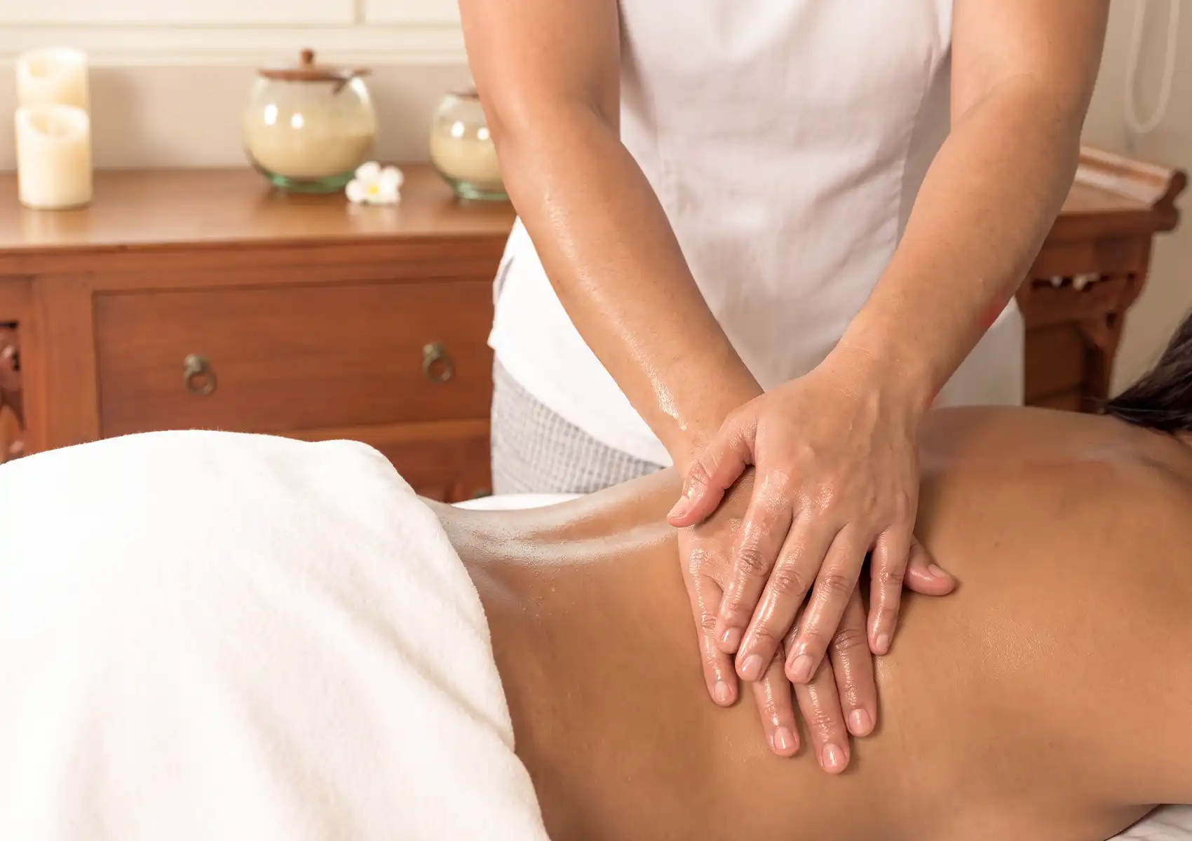 Close-up of a professional spa therapist's hands performing a soothing oil massage on a client's back at the best spa in ubud.